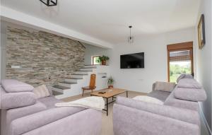 uma sala de estar com dois sofás e uma parede de tijolos em Stunning Home In Donji Prolozac With Kitchen em Donji Proložac