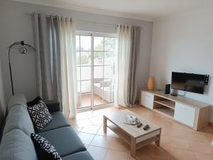 sala de estar con sofá azul y TV en Mar à Vista Algarve Summer, en Portimão