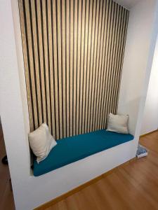 a bed with two pillows on top of a wall at FeWo-Julius am Weser-Sandstrand in Berne