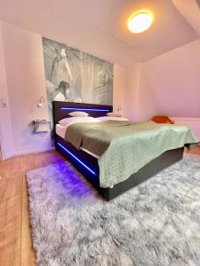a bedroom with a bed with a rug and purple lighting at FeWo-Julius am Weser-Sandstrand in Berne