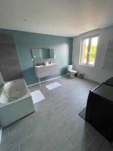 ein Badezimmer mit einer Badewanne, einem Waschbecken und einem WC in der Unterkunft Cosy house in Somain