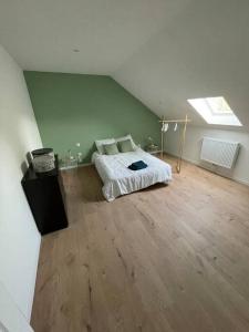 a bedroom with a bed and a wooden floor at Cosy house in Somain