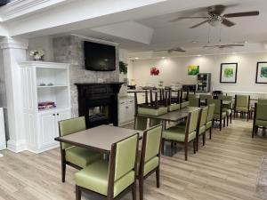 a dining room with tables and chairs and a fireplace at Quality Inn Richmond in Richmond