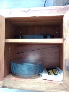 a wooden cabinet with a stack of plates in it at Chalés do Apolinário in Tiradentes