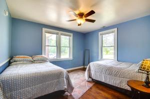 una camera blu con 2 letti e un ventilatore a soffitto di Downtown Hermann Vacation Home Near Wineries! a Hermann