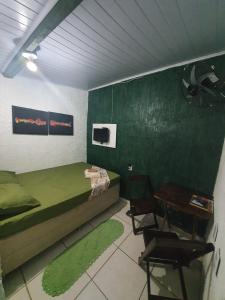 1 dormitorio con 1 cama, mesa y sillas en Pousada das Artes 1 en Mongaguá