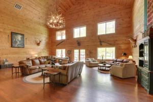 duży salon ze skórzanymi meblami i żyrandolem w obiekcie Fraziers Bottom Cabin on 800 Acres of Land with Lake 
