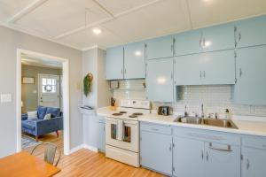 a kitchen with blue cabinets and a sink and a table at Sturgeon Bay Home about 6 Mi to Potawatomi State Park in Sturgeon Bay +16 photos