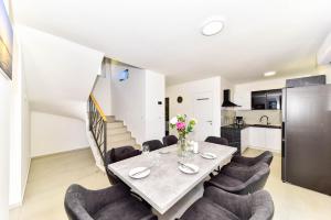 a dining room with a table and chairs and a kitchen at Villa Adriatic Sunrise in Šibenik