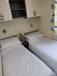 - 2 lits dans une petite chambre avec des draps blancs dans l'établissement Calm & Cosy (sleeps up to 6) - Oakdene Forest Park, à Ferndown