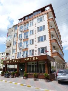 ein Hotelgebäude auf einer Straße mit einem Auto vor der Unterkunft in der Unterkunft Gelibolu Hotel in Gelibolu