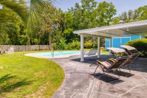 un patio con 2 sillas y una mesa junto a la piscina en Gulf Breeze Vacation Rental with Pool Access! en Gulf Breeze
