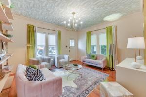 a living room with pink furniture and green curtains at Charming Lake Charles Vacation Rental with Yard in Lake Charles