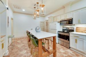 a kitchen with white cabinets and a table with chairs at Charming Lake Charles Vacation Rental with Yard in Lake Charles