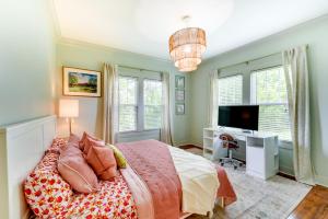 a bedroom with a bed and a tv and windows at Charming Lake Charles Vacation Rental with Yard in Lake Charles