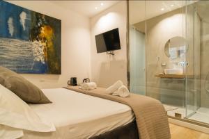 a bedroom with a bed and a glass shower at Four Luxury Suite in Palermo