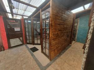 Zimmer mit Holztüren und Fenstern in einem Gebäude in der Unterkunft Pousada das Artes 1 in Mongaguá