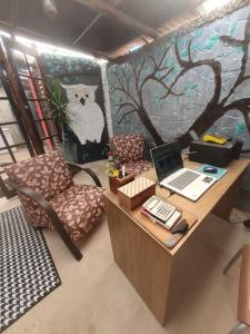 biuro z biurkiem z laptopem i krzesłem w obiekcie Pousada das Artes 1 w mieście Mongaguá
