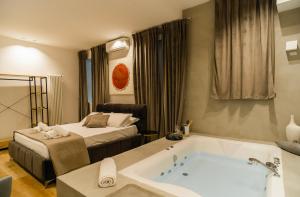 a hotel room with a bath tub and a bed at Four Luxury Suite in Palermo