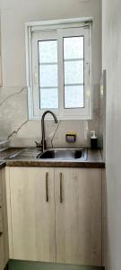 a kitchen with a sink and a window at Petros Studios Valtos in Parga
