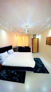 een slaapkamer met een wit bed en een zwart tapijt bij Riad dar asalam in Agadir