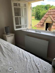 1 dormitorio con cama y ventana en Le Périgourdin, en Saint-Cyprien