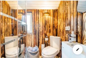 łazienka z toaletą i umywalką w obiekcie Roulotte du puits avec jacuzzi et sauna privatif 