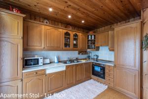 una cucina con armadi in legno, lavandino e forno a microonde di Apartments Artemida a Bled