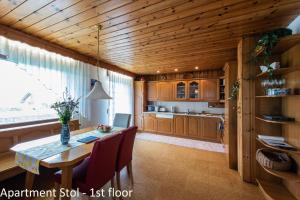 una cucina con tavolo da pranzo, sedie e soffitto in legno di Apartments Artemida a Bled