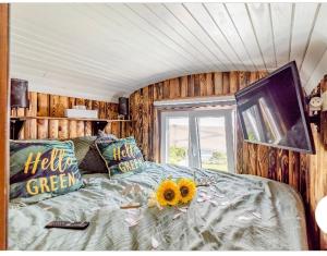 a bedroom with a bed with a sunflower on it at Roulotte du puits avec jacuzzi et sauna privatif 