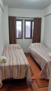 2 Betten in einem Zimmer mit 2 Fenstern in der Unterkunft 9y45 in La Plata
