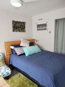 a bedroom with a bed with blue sheets and pillows at Funky Urban Studio near UNR in Reno