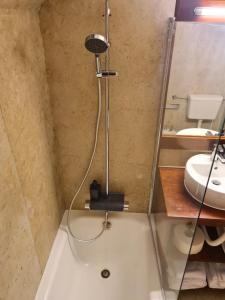 um chuveiro na casa de banho com um lavatório e uma banheira em TROIAMAR em Tróia
