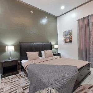 a bedroom with a large bed and two lamps at Matteo's hus VILLA RENTAL in Zamboanguita