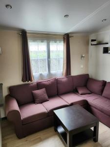 a living room with a purple couch and a table at Mer et soleil in Les Sables Vignier