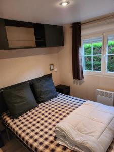 a bedroom with a bed with a checkered blanket at Mer et soleil in Les Sables Vignier