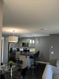 a kitchen and living room with a table and chairs at Lovely 2 bedroom 2 bathroom plus den in Calgary