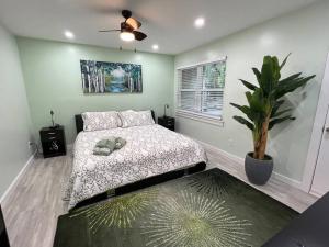 - une chambre avec un lit et une plante en pot dans l'établissement Tranquility in paradise- 2 bedroom villa w/parking, à Île de Hilton-Head