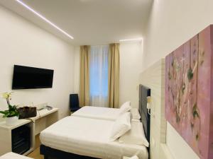 Hotel Fioralba في ميلانو: غرفة فندق بسرير وتلفزيون