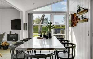 une salle à manger avec une table et des chaises blanches dans l'établissement 4 Bedroom Stunning Home In Bogense, à Bogense