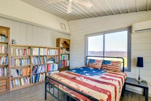 a bedroom with a bed in a room with book shelves at Scenic Ranch House with Fishing Pond! 