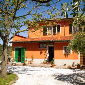 Maison orange et blanche avec portes vertes dans l'établissement B&B Il Ramaiolo, à Santa Maria a Monte