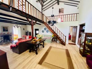 a large living room with a wooden floor and a staircase at Quinta Do Sol Poente in Feteiras