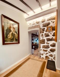 a room with a painting of a woman on a stone wall at Quinta Do Sol Poente in Feteiras