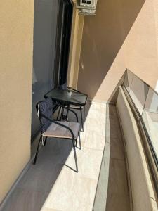 una mesa y una silla en el balcón en Glamur Apartman - Ulcinj, en Ulcinj