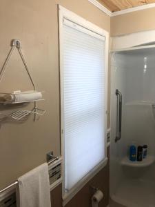 une salle de bain avec une fenêtre avec les stores baissés dans l'établissement Entire detached 3-bedrooms cute home in Cornwall area, à Cornwall