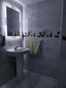 W białej łazience znajduje się umywalka i lustro. w obiekcie White House w mieście Azrou