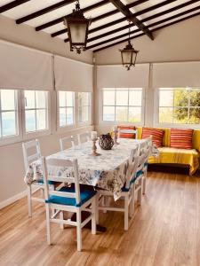 a dining room with a table and chairs and a couch at Quinta Do Sol Poente in Feteiras