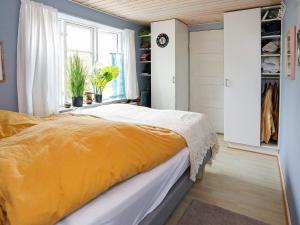 a bedroom with a bed with an orange blanket at 6 person holiday home in Otterup-By Traum in Otterup