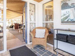 una silla de mimbre sentada en un porche con una mesa en 8 person holiday home in Skagen, en Skagen